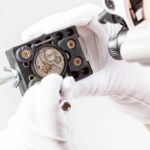 watchmaker in lenses repairs old wristwatch